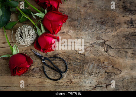 red roses twine scissors on wood table Stock Photo