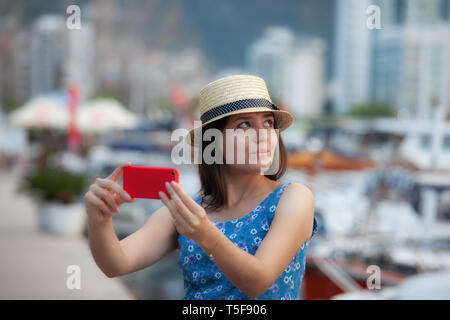 Young travelling woman in hat taking selfie photos