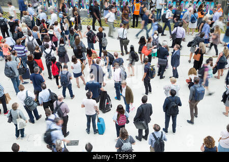 Travellers and commuters wait for train on the busy concourse at Waterloo railway station in London Stock Photo