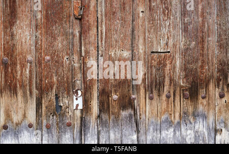 Green padlock on old brown wooden door Stock Photo