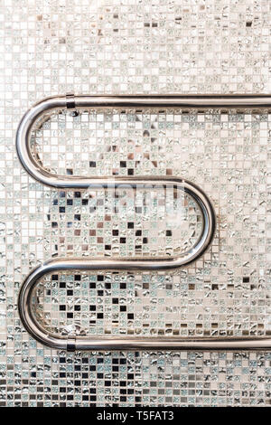 Bathroom interior in art deco style. Chrome towel warmer on a background of mirror mosaic ceramic tiles Stock Photo