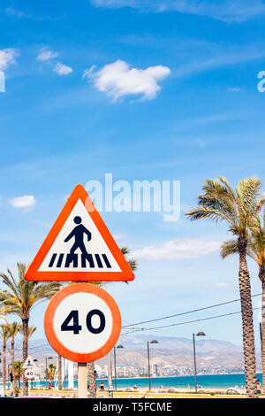 speed limit and pedestrian crossing signs by the beach in Alicante spain Stock Photo