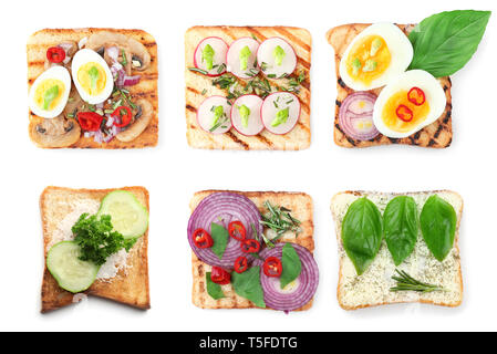 Different delicious toasts with vegetables and eggs on white background Stock Photo