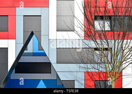 Tree & colourful abstract geometric  architectural shapes with triangle on cladding facade of modern student accommodation building in Southend UK Stock Photo
