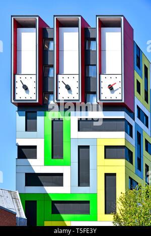 Clock hands on  unusual tall clock tower on top of colourful modern architecture purpose built student accommodation flats colour geometric pattern UK Stock Photo