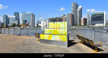 River Thames infographic panel riverside footpath & cycle path modern building skyline along far shoreline at Canary Wharf from Greenwich Peninsula UK Stock Photo