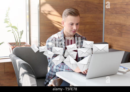 Young freelancer with laptop checking an email in cafe Stock Photo