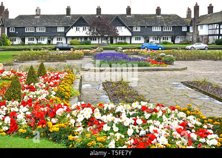 Terraced housing in Port Sunlight model village flowers in public garden all built by Lever Brothers for factory workers  Wirral Merseyside England UK Stock Photo