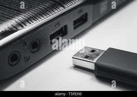 close up of black usb pen drive and the side of black laptop Stock Photo
