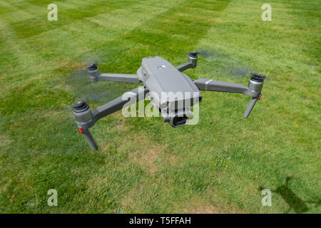 Looking down birds eye view onto a flying DJI Mavic 2 PRO personal Drone flying very low near to the ground Stock Photo