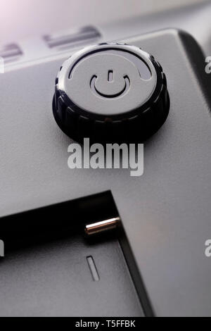 On off button with power adjustment function. Brilliant contacts of the connector for the battery in a plastic black case. Dark contrast view Stock Photo