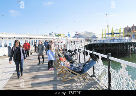 People enjoying the sunny weather on the boardwalk of Brighton Palace Pier, East Sussex, England, UK Stock Photo