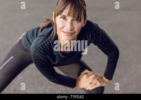 Sportive woman doing her fitness training outdoors, stretching Stock Photo