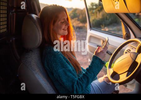 Young woman on a road trip, using smartphone Stock Photo
