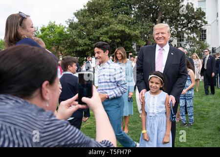 U.S President Donald Trump poses for selfies with guests during the White House Easter Egg Roll event on the South Lawn of the White House April 22, 2019 in Washington, DC. This is the 141st year for the annual spring event. Stock Photo