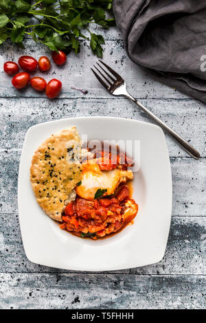 Shakshouka with pita bread on plate Stock Photo