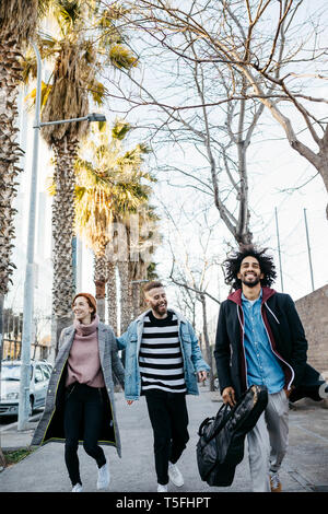 Three happy friends walking in the city Stock Photo