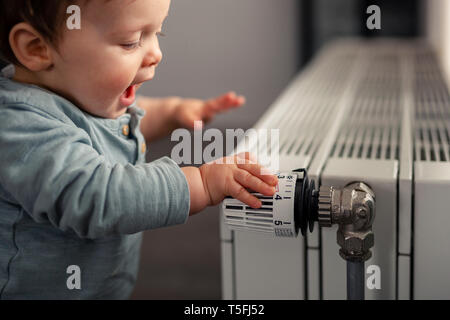 https://l450v.alamy.com/450v/t5fj52/excited-baby-boy-playing-with-thermostat-of-heater-t5fj52.jpg