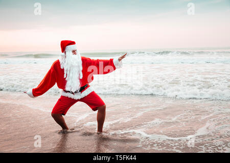 Thailand, man dressed up as Santa Claus posing on the beach at sunset Stock Photo