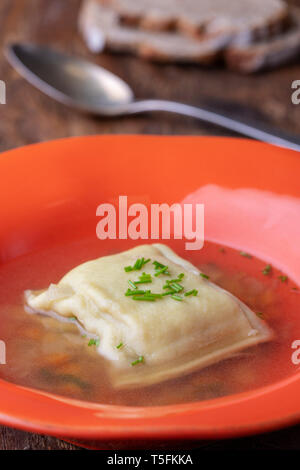 swabian maultasche in broth on wood Stock Photo