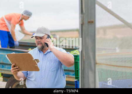 Farm worker talking on the phone Stock Photo