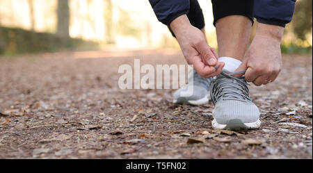 Man tying laces of running shoes before training. Stock Photo