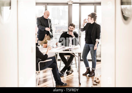 Business people work relaxed together in bright office Stock Photo