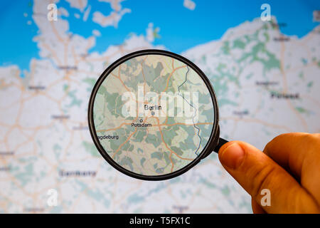 Berlin, Germany. Political map. City visualization illustrative concept on display screen through magnifying glass in the hand. Stock Photo