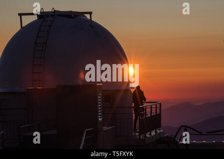 LA MONGIE, FRANCE - MARCH 19: a woman taking pictures of the mountains from an astronomical observatory during a sunrise, Occitanie, La Mongie, France Stock Photo