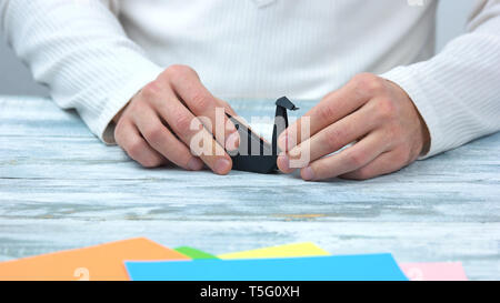 Black origami swan on wooden background. Stock Photo