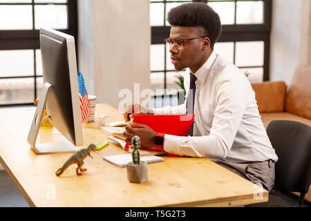 Handsome young man doing his work carefully Stock Photo