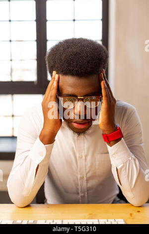 Good looking young man being tired from work Stock Photo