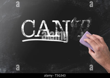 changing CAN’T to CAN by erasing letter T with blackboard eraser, motivation concept Stock Photo