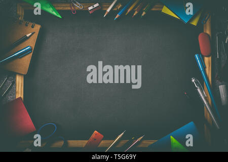 Blackboard with various school supplies and copy space in the middle, top view Stock Photo