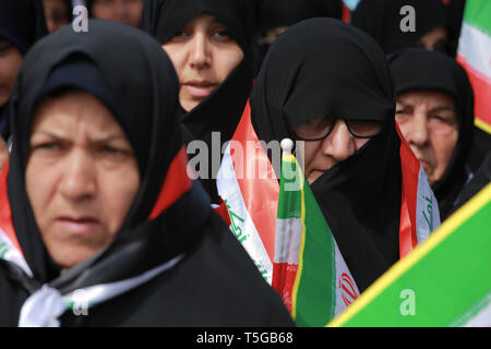Baghdad, Iraq. 24th Apr, 2019. Women holding flags of Iran and Iraq attend a conference organized by the predominantly Shia Muslim Popular Mobilization Forces (PMF) to honour Iranian fighters who died fighting the so-called Islamic State (IS) terror group. Credit: Ameer Al Mohammedaw/dpa/Alamy Live News Stock Photo