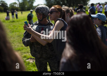 June 8, 2014 - St Mere Eglise, Normandy, France - A tourist takes a selfie with an American soldier after he jumped into a landing zone near the La Fiere Bridge outside Sainte-MÃ¨re-Ã‰glise, Normandy, France, during a demonstration jump June 8, 2014. Nearly 700 paratroopers from the U.S., French, German, United Kingdom, Dutch and Norwegian militaries jump into the area to commemorate the start of D Day when the U.S. 82nd Airborne jumped into the area. Thousands of people visited the region to commemorate the invasion's anniversary. This year marks the 70th anniversary of the landings that libe Stock Photo