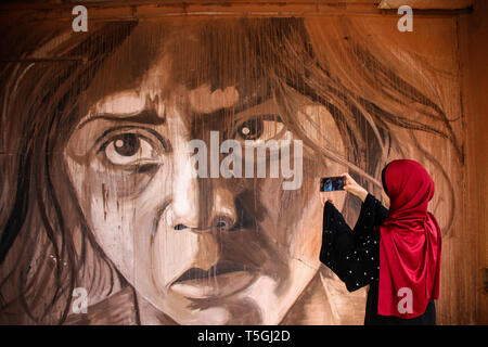 Gaza City, Palestine, 24 April 2019. 24th Apr, 2019. Palestinian artist Ali Al-Jabali opens his art exhibition titled 'Dreamers among the rubble'' on the ruins of the Italian tower which was severely damaged by Israeli airstrikes during the 2014 Israel-Gaza conflict. On 26 August 2014 Israeli rockets hit the mixed-use ''Italian complex'', a 15-storey building hosting residential units and commercial offices, during the 2014 Israeli attack on the Gaza Strip Credit: Ahmad Hasaballah/IMAGESLIVE/ZUMA Wire/Alamy Live News Stock Photo