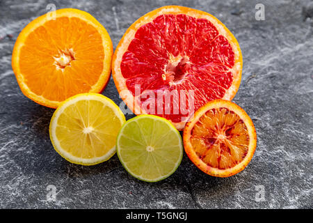 Sliced citrus fruits on slate Stock Photo