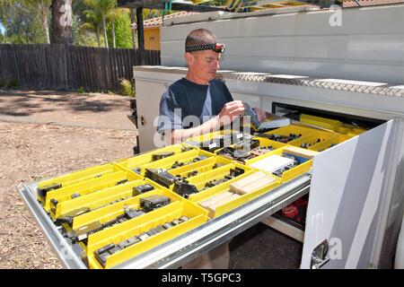 A young electrical repairman looking over his real fuses breakers and such on job site in California USA making a living. Stock Photo