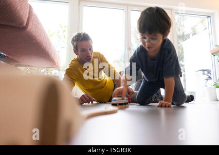 Father and son playing at home with a toy train Stock Photo