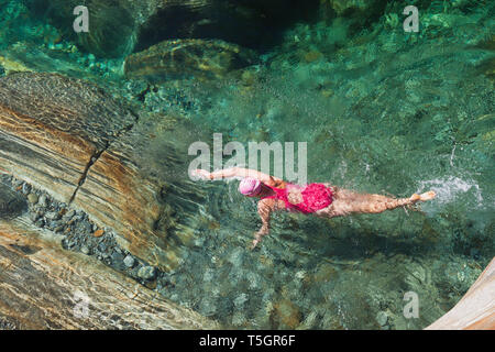 Switzerland, Ticino, Verzasca Valley, woman swimming in refreshing Verszasca river Stock Photo