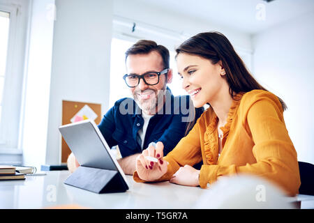 Two colleagues working together on tablet in office Stock Photo