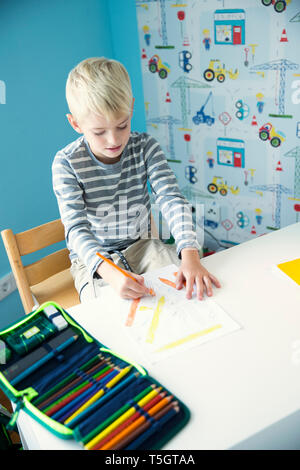 Boy drawing on paperk at desk in children's room Stock Photo