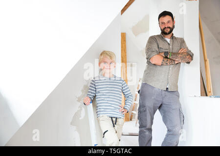 Portrait of confident father and son working on loft conversion Stock Photo