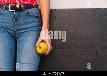 Woman's hand holding apple, partial view Stock Photo