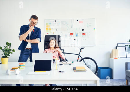 Two colleagues working together on laptop in office Stock Photo