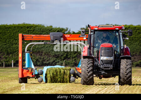 Kirwee, Canterbury, New Zealand, March 27 2019: A demonstration of a hay bale wrapper at work at the South Island Agricultural Field Days event Stock Photo