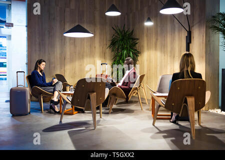 Business people sitting in hotel lobby, working Stock Photo