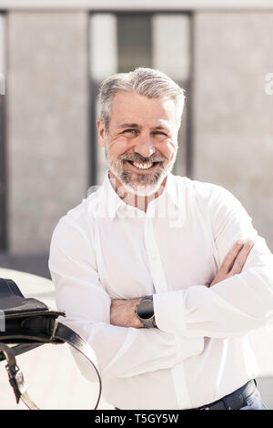 Portrait of smiling confident mature businessman outdoors Stock Photo
