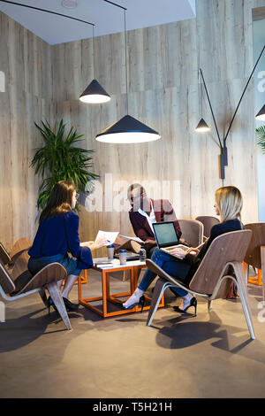Business people sitting in hotel lobby, working Stock Photo